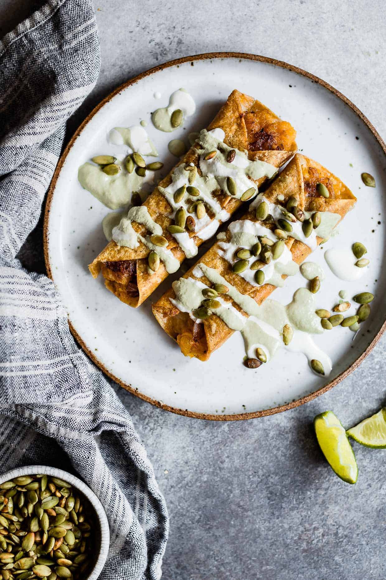 cheesy pumpkin taquitos with roasted jalapeño pepita crema