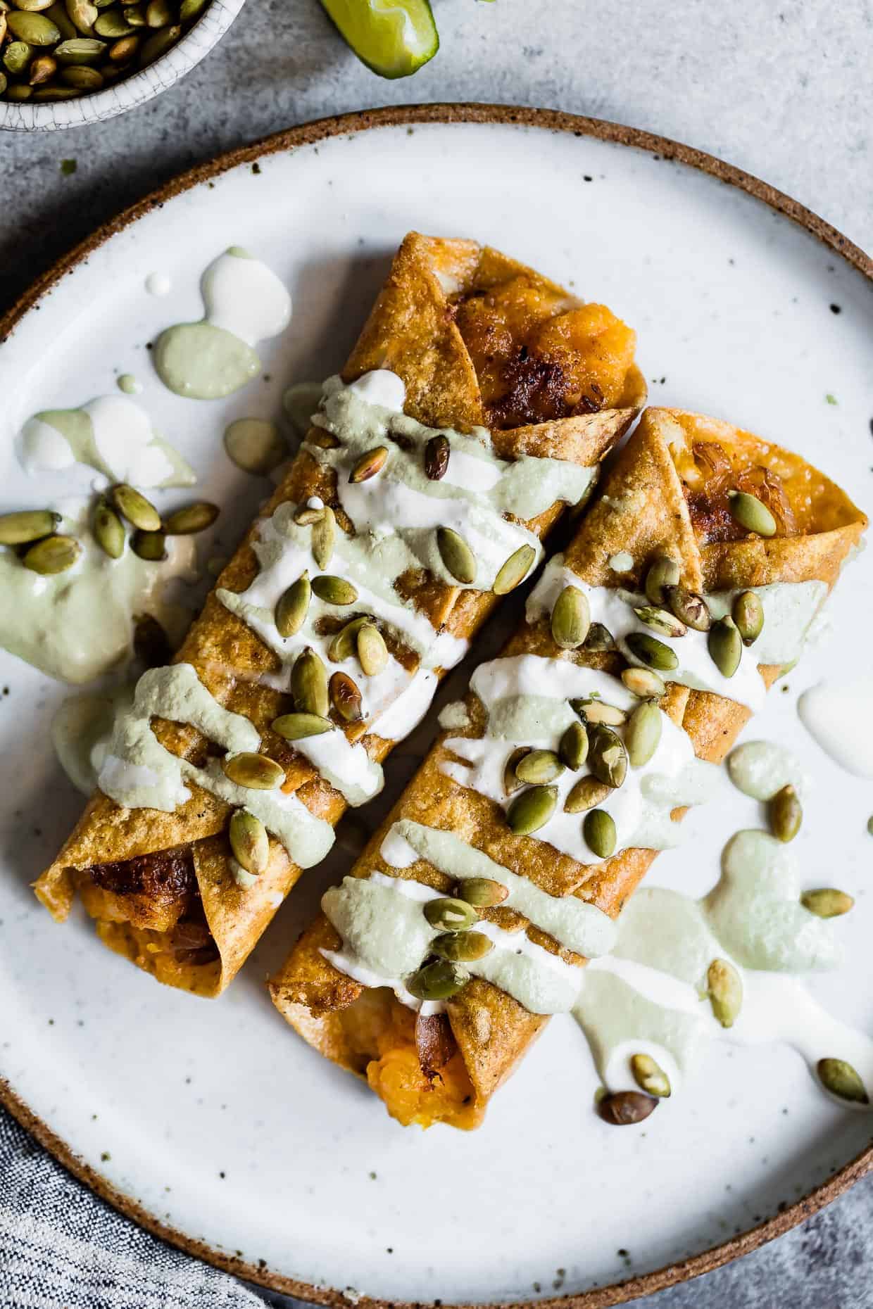 Cheesy Pumpkin Taquitos with Roasted Jalapeno Pepita Crema