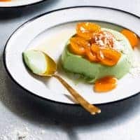 Creamy matcha Panna Cotta on white plate with gold spoon