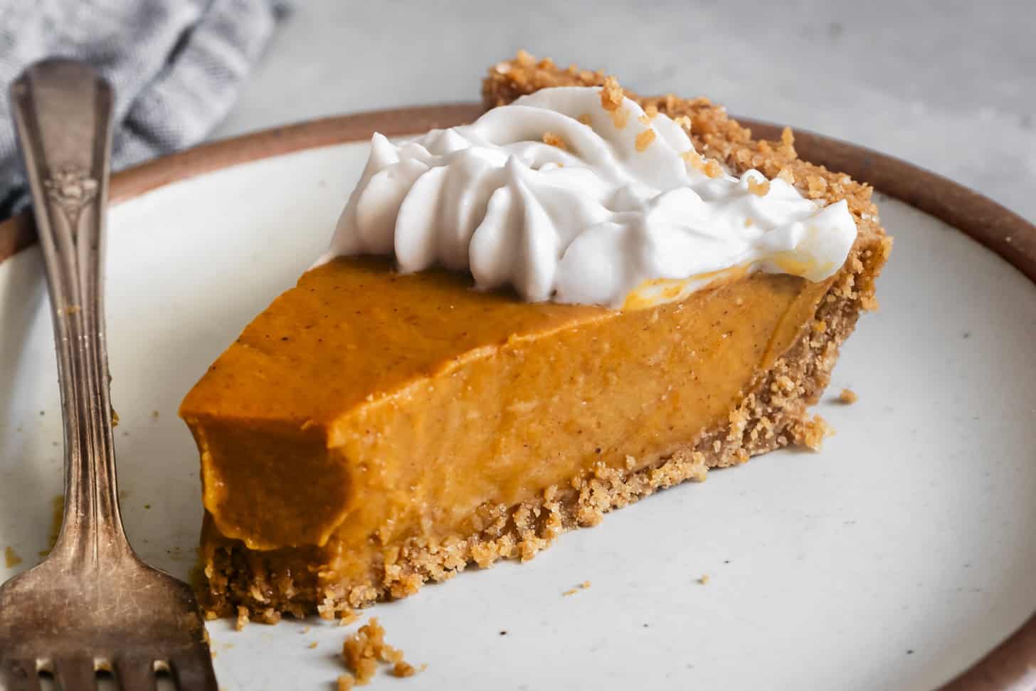 Slice of gluten-free dairy-free pumpkin pie with graham cracker crust