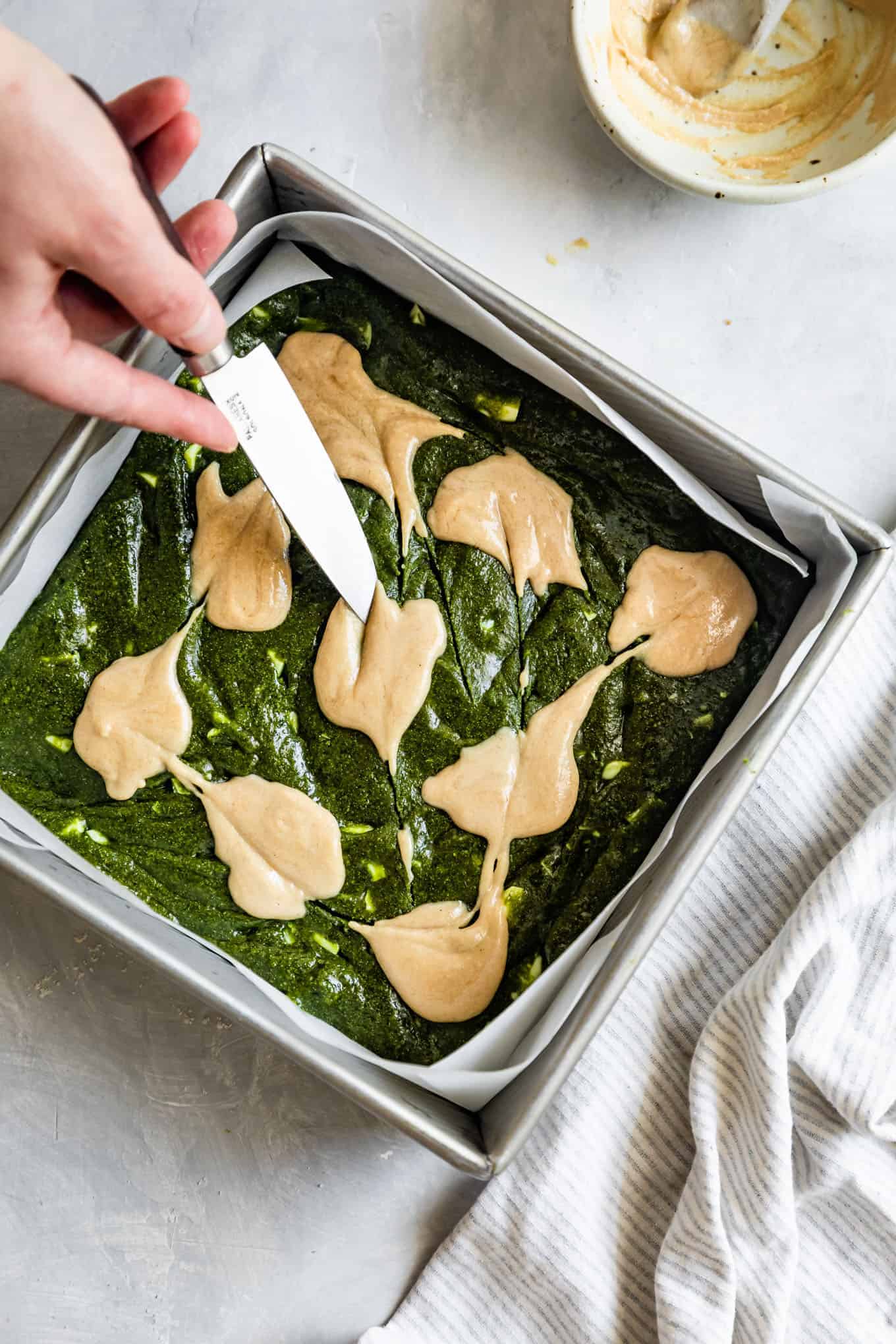 Tahini Swirling in Matcha Brownies