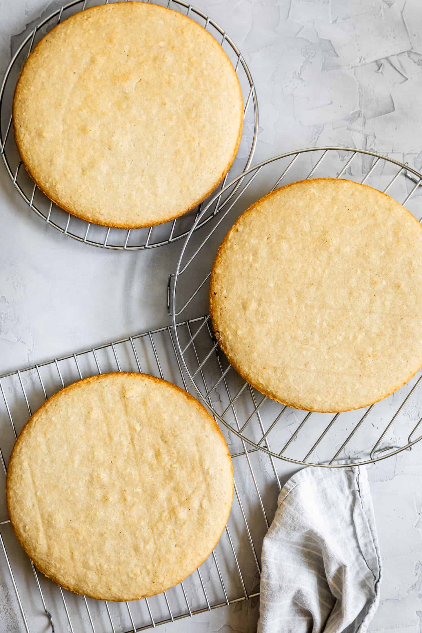 Layers of Gluten-Free Coconut Cake Cooling on Racks