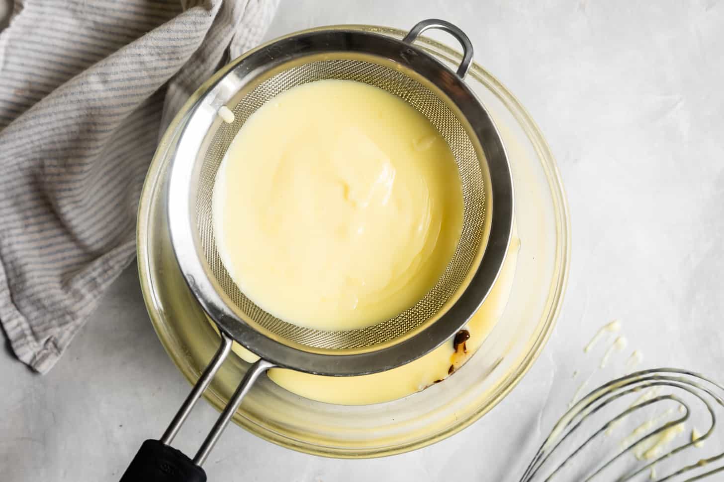 Pouring Custard through Fine Mesh Sieve over Chocolate