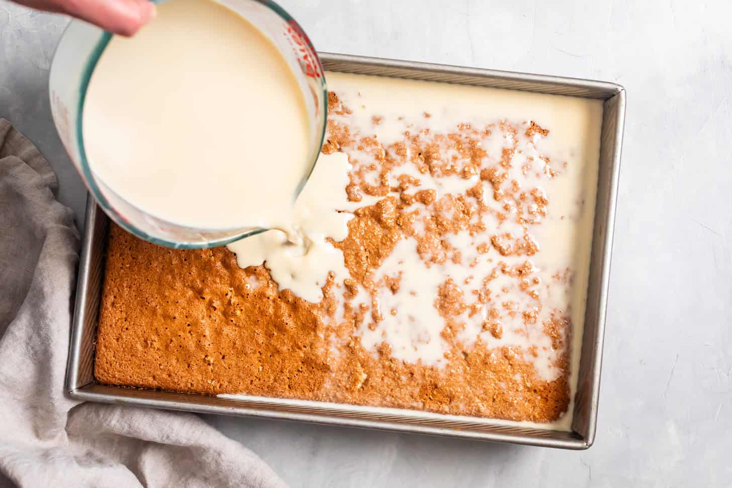 Pouring Tres Leches over Cake for Gluten-Free Tres Leches Cake