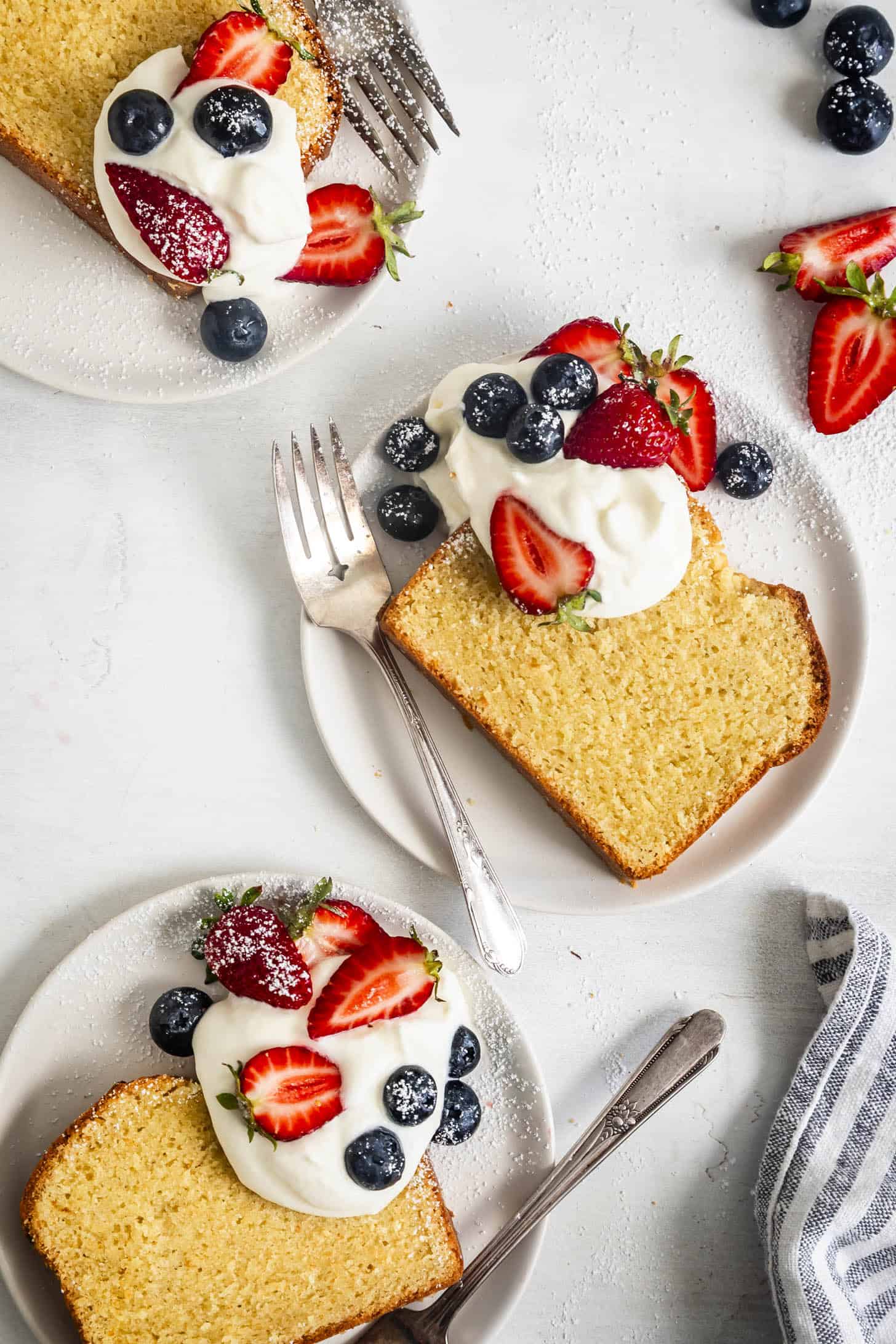 Slices on Plates of Gluten-Free Pound Cake with Whipped Cream and Berries