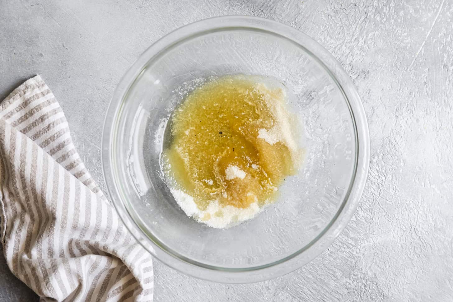 Pouring melted butter over sugar for cornbread