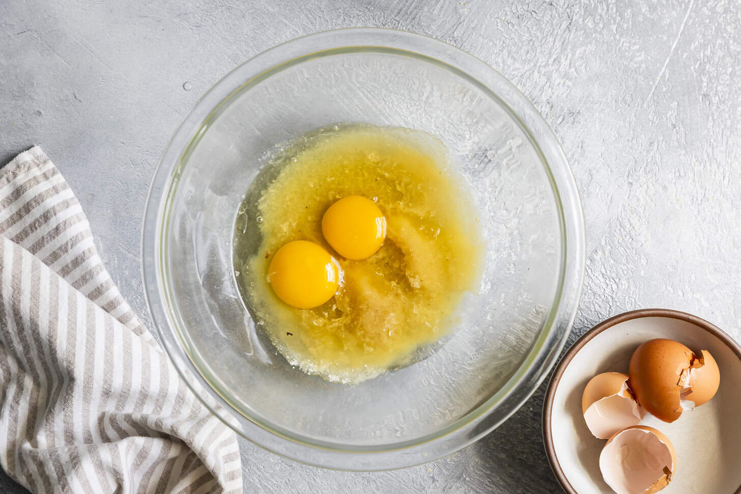 Adding eggs to mixed butter and sugar for cornbread