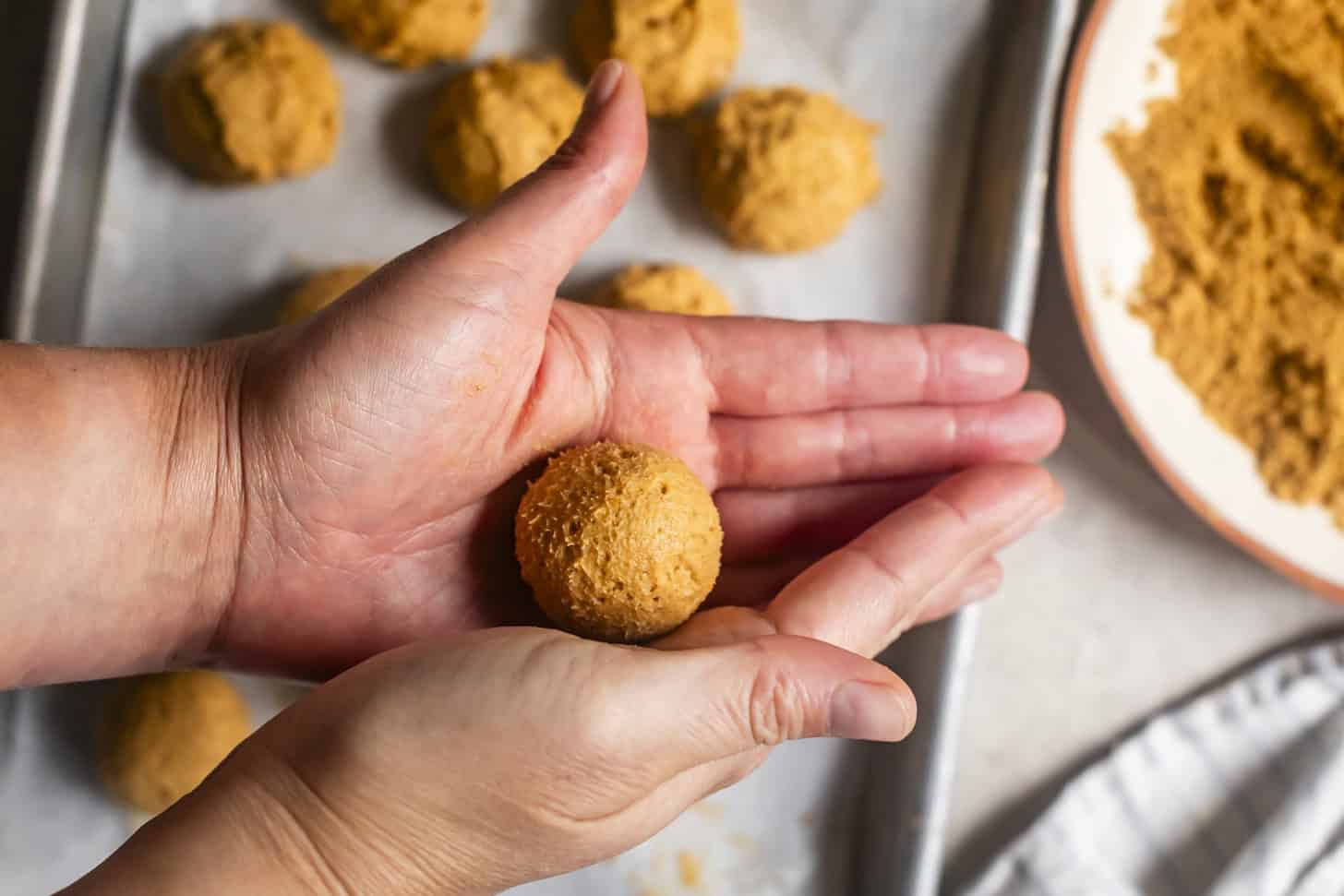 Rolling Pumpkin Cheesecake Truffles in Palms
