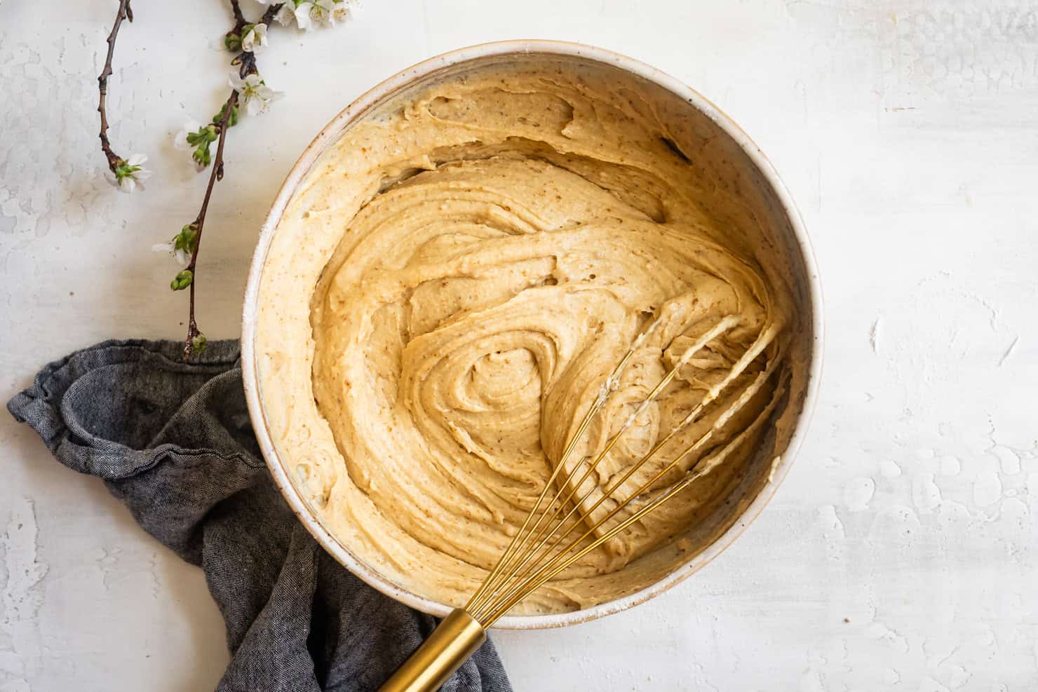 A bowl of creamy batter for sweet mochi waffles with a whisk